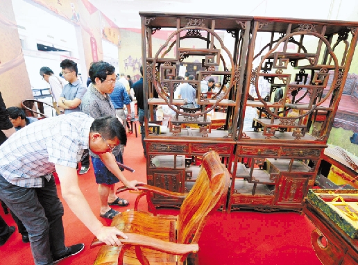 某艺术收藏品博览会，红木家具展位前人流不断。