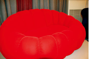 大红沙发可是房间最大的亮点。平时宅在家里时，她很喜欢窝在沙发里看碟、听歌。