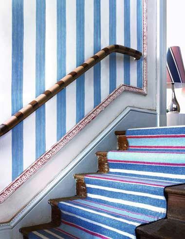 楼梯扶手上绘以彩色条纹，更能突显出木制感觉，并与整个空间融为一体