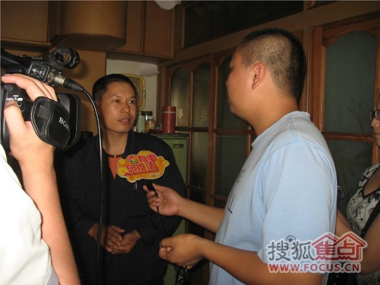 张师傅正在和顾记者说明造成地板出现这样情况的原因。