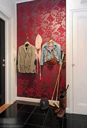 进门的墙面上做了衣架用花色的紫红壁纸作为背景