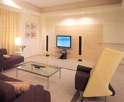 温馨舒适风格的客厅，米黄色的沙发和窗帘、晕黄色的背景灯、简约的茶几、现代的音响设备营造出和谐舒适的氛围。