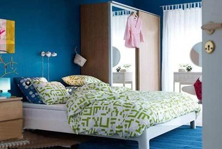 宁静的深蓝色贯穿始终，背景墙与地毯的颜色一致，延伸了视觉范围，同色系的绿则体亮了卧室的整体色调