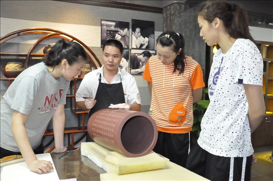 图为中国女篮观看L&D陶瓷的艺术作品制作过程