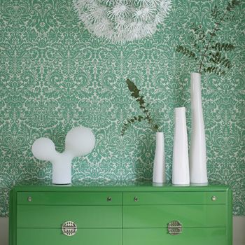 浅绿色的花纹壁纸和果绿色的柜子相映成趣，配上线条优美的白色陶瓷，这样的客厅你喜不喜欢