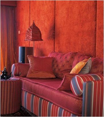 沙发后面的主题墙用软包的手法来处理，面料要选加厚绒面的，色彩自然是暖色系，暗橘色使得空间看起来又温暖又有年代感