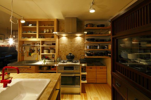 装修后厨房改造成欧陆风格的开放式厨房，采用暖黄色调及木制橱柜，与起居室的整体风格色调相呼应