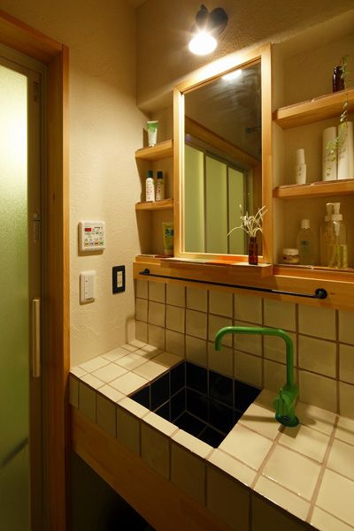 浴室的洗手台选用了墨西哥瓷砖，硅藻土墙壁配上木制壁柜，显得清新自然