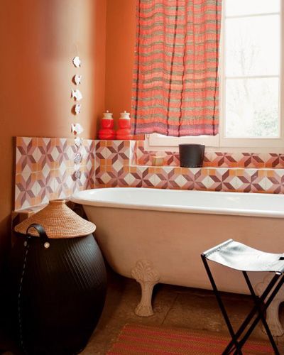 不同于大部分中国家庭的浴室，这个浴室只在浴缸周围加装了瓷砖，与橙色墙面形成了对比