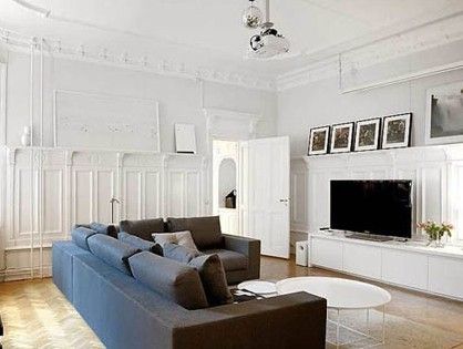 白色墙面上的浮雕装饰与钢琴、壁炉相互呼应，都是略带古典欧风的设计。而L型的转角沙发却保持着单一的线条，同简洁的电视柜一起布置出一个简约的空间环境