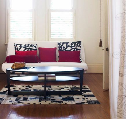 乳白色的沙发简洁干练，红黑两色的靠垫使整体有了变化