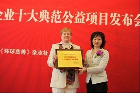 图为美克美家副总裁Betsi领取“2011中国企业十大典范公益项目”奖牌