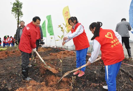 东鹏集团董事长何新明与学生一起植树