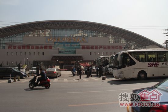 四辆大巴载着150名植树军团在北京建材经贸大厦门前整装待发