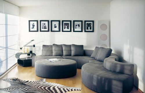 小户型的客厅最适合简单的搭配布置，一款流行的圆转角沙发在客厅蜿蜒，似乎也扩大了视野。动物皮地毯让这个小客厅霸气外露