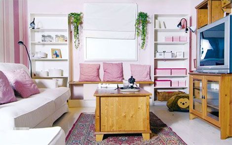 客厅的墙面用粉红色壁纸铺贴，与白色的家具相互呼应；沙发为宽大的白色双人沙发，满足了使用的舒适程度