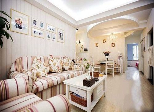 客厅摆放了鲜红色布艺沙发，与居室散发的田园风格甚为匹配。以粉橙色为主调，暖意无限，亦能为客厅凸出童话色彩