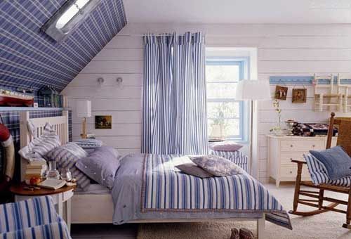 蓝白相间的条纹容易营造出夏日清爽的室内家居风格，卧室整体色调简单清新，条纹的床品跟其条纹相呼应，床头背景墙的格纹壁纸则丰富了室内视觉感受
