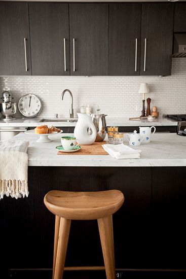 深咖啡色的橱柜搭配银色不锈钢的手把，在面积适中的开放式厨房里面使用最合适，深沉的颜色搭配墙面白色的瓷砖，给人现代的中庸感