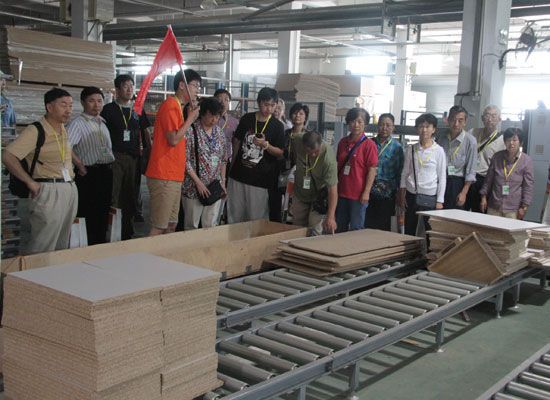 来自北京的业主在工作人员带领下，参观欧派橱柜柜体生产车间，感受欧派产品品质
