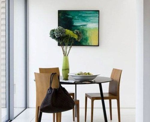 在白色为主题色彩的餐厅中，餐桌和餐椅不适合过于复杂的，小脚的原木色餐椅好小圆桌都给人简约之感，和空间风格十分协调