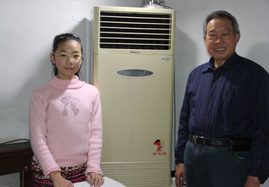 张先生和9岁的外孙女在海尔空调前合影