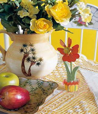 黄色桌布上加铺一块蕾丝桌布可以令田园感更纯粹，田园风格花瓶瓷器能够表露出居室主人对田园风格的了然