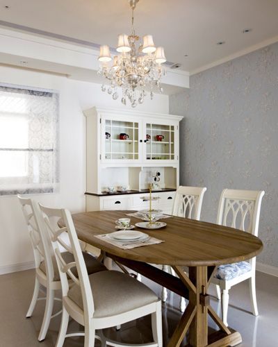 家具选搭家具为主体的餐厅设计搭配水晶灯营造用餐氛围，立面美式壁纸延伸入廊道采以同色系漆料铺陈，呈现淡淡空间一致性