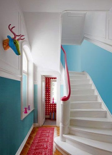 楼梯空间整体的蓝白色调设计显得轻盈并带有节奏感，连接上下两个空间的楼梯的扶手采用了一抹艳红色来点亮空间，并呼应着空间里的各类红色装饰单品
