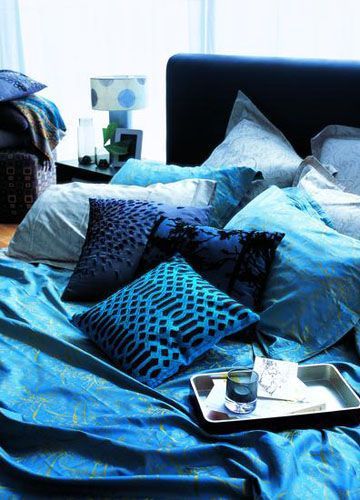 深浅不一的蓝灰色床品，深蓝色的抱枕，湖蓝色几何条纹靠垫，以及那渐渐浅下去的天蓝，将成熟却宽容的温暖气息在居室内不断延续