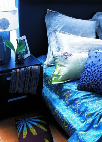 浅蓝色印花床单与淡绿色、灰色和深蓝色相衬，低调的印花图案为室内增加温馨的同时，呈现的却是低调不失华贵的独特气息