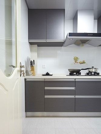 厨房采用灰白色，白色的门、墙面和地面搭配灰色的整体橱柜，典型的现代简约风格装修
