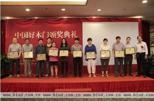 图为：2013中国木门行业全国优秀服务企业与颁奖嘉宾合影留念