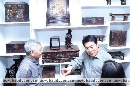 张德祥在向同行的媒体、当地企业家讲解古家具的历史、文化
