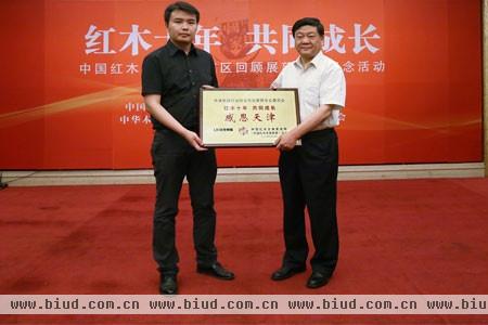 联合传媒代表向天津一品堂董事长白希鸻颁授“红木十年 共同成长”铜牌