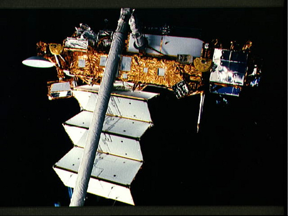 “发现”号STS-48任务进行部署前检测，有效载荷舱上方的远程操纵系统末端执行器牢牢抓住UARS卫星